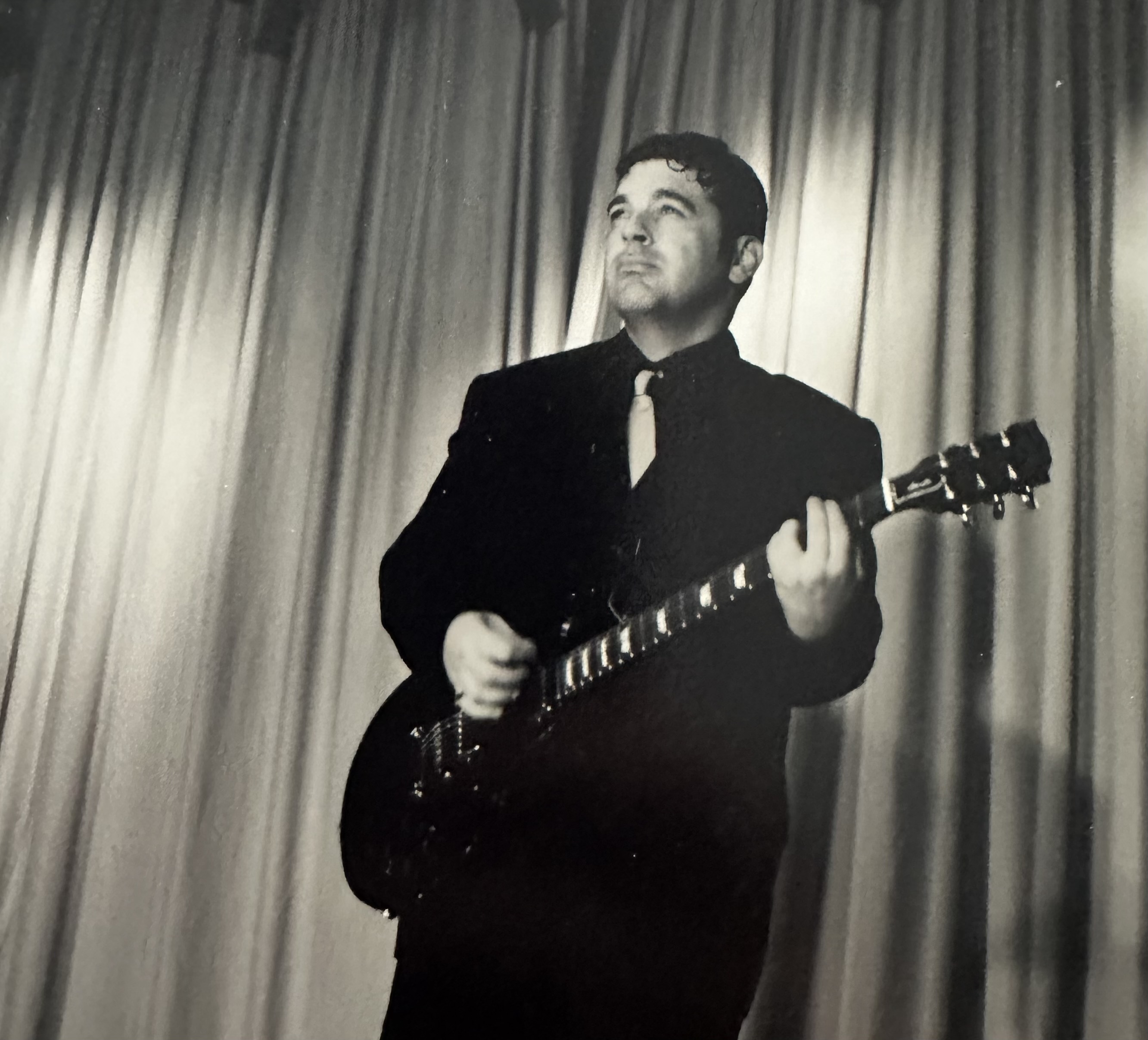 John on stage with electric guitar